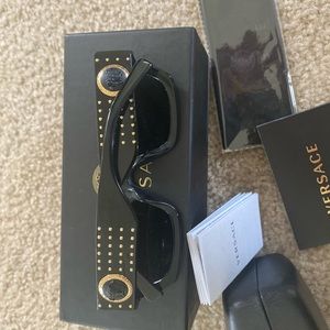 Black Versace sunglasses with gold studs.